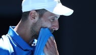 Serbia's Novak Djokovic wipes his face between games during his men's singles semifinal match against Germany's Alexander Zverev on day thirteen of the Australian Open tennis tournament in Melbourne on January 24, 2025. (Photo by Martin KEEP / AFP)