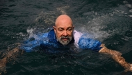 German aerospace engineer Rudiger Koch, 59, jumps into the water to celebrate breaking the Guinness world record on January 24, 2025. (Photo by MARTIN BERNETTI / AFP)