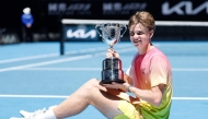 Switzerland's Henry Bernet poses with the winner's trophy after his victory in junior boys' singles final match in Melbourne on January 25, 2025. (Photo by Martin Keep / AFP) 