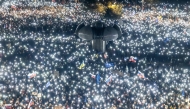 Hundreds of people hold up lights as they take part in an anti-government protest organized by political activists affiliated with the 