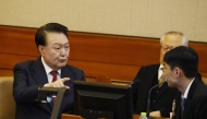 South Korea’s impeached President Yoon Suk Yeol (L) speaks to his lawyers as he attends the fourth hearing of his impeachment trial over his short-lived imposition of martial law at the Constitutional Court in Seoul on January 23, 2025. (Photo by JEON HEON-KYUN / POOL / AFP)