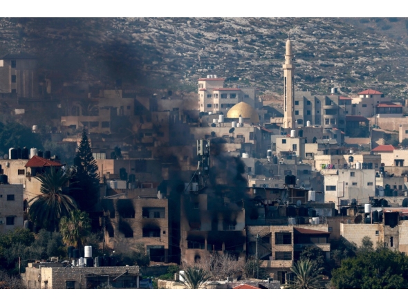 Smoke billows from a burning building during an Israeli raid on the Jenin camp for Palestinian refugees on January 25, 2025. (Photo by Jaafar ASHTIYEH / AFP)
