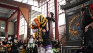 Lin Xinmeng (C) holding a female lion dancer during a practice session at an ancestral temple in Shantou, in southern China's Guangdong province. (Photo by Jade Gao / AFP) 