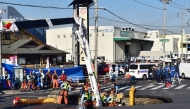 Firefighters work to rescue a truck driver after his vehicle was swallowed up by a sinkhole at a prefectural road intersection, in the city of Yashio, Saitama Prefecture on January 28, 2025. Photo by JIJI Press / AFP