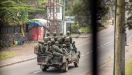 Armed men travel in a pickup truck, devoid of any insignia or markings, as they drive through a street in Goma on January 28, 2025. (Photo by AFP)