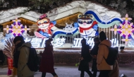 Visitors walk past installations themed on the 2025 Asian Winter Games at China's 