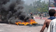 Burning tires block a road during a demonstration against the escalating conflict in eastern Democratic Republic of Congo in Kinshasa, on January 28, 2025. (Photo by Hardy BOPE / AFP)
