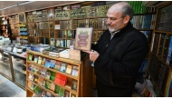 A bookseller shows a volume that was reportedly banned during the rule of Syria's ousted president Bashar Al Assad. (Pic: Louai Beshara / AFP) 