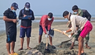 Bangladeshi marine rescuers prepare to bury a dead olive ridley sea turtle at a beach in Cox's Bazar on January 29, 2025. (Photo by Suzauddin Rubel / AFP)