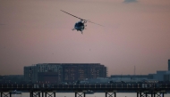 A helicopter flies near the crash site of the American Airlines plane on the Potomac River on January 30, 2025 in Arlington, Virginia. Win McNamee/Getty Images/AFP