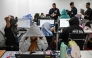 Workers sit at their desks during a raid by agents of the Presidential Anti-Organised Crime Commission (PAOCC) and the National Bureau of Investigation at an office of a suspected online scam farm in Manila on January 31, 2025. Photo by JAM STA ROSA / AFP