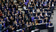 Leader of Germany's Christian Democratic Union (CDU) Friedrich Merz (front row L) looks on as his parliamentary group and of the Bavarian conservative Christian Social Union (CSU) party applaud while members of the far-right Alternative for Germany (AfD) look on during a debate at the Bundestag (lower house of parliament) focusing on immigration, on January 31, 2025 in Berlin. Photo by Odd ANDERSEN / AFP.