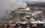 Fire engines are seen on a road as smoke rises from the roof of the National Hangeul Museum in Seoul on February 1, 2025. (Photo by YONHAP / AFP) 