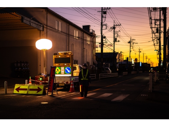 A worker controls the traffic as rescue operations continue for the truck driver in Yashio, Saitama Prefecture on January 30, 2025. (Photo by Philip Fong / AFP)