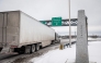 A truck drives on its way to enter the United States at a border crossing at the Canada-US border in Blackpool, Quebec, Canada, on February 2, 2025. (Photo by Andrej Ivanov / AFP)