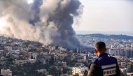 A journalist looks on as smoke billows from the site of several explosions during an Israeli raid in the occupied West Bank city of Jenin on February 2, 2025. (Photo by MOHAMMAD MANSOUR / AFP)
