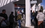 People queue to buy ferry tickets to leave the Greek Island of Santorini at a travel agency in the town of Fira on February 4, 2025. (Photo by Aris Messinis / AFP)