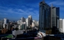 A general view shows a BTS commuter train as it passes with the backdrop of the Bangkok skyline on June 2, 2023. Photo by Manan VATSYAYANA / AFP