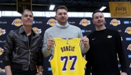 Luka Doncic (C) of the Los Angeles Lakers holds his new jersey while standing alongside general manager Rob Pelinka (L) and head coach JJ Redick (R) during a press conference at UCLA Health Training Center on February 04, 2025 in El Segundo, California. (Photo by Harry How / GETTY IMAGES NORTH AMERICA / Getty Images via AFP)
