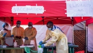 Medical personnel wear protective medical clothing while disinfecting the area in preparation for the arrival of volunteers during the launch of an Ebola trial vaccination campaign at Mulago Referral Hospital in Kampala on February 3, 2025. (Photo by Badru Katumba / AFP)
