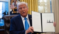 US President Donald Trump shows an executive order withdrawing his country from a number of United Nations bodies in the Oval Office of the White House on February 4, 2025 in Washington, DC. (Photo by Andrew Caballero-Reynolds / AFP)