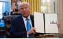 US President Donald Trump shows an executive order withdrawing his country from a number of United Nations bodies in the Oval Office of the White House on February 4, 2025 in Washington, DC. (Photo by Andrew Caballero-Reynolds / AFP)