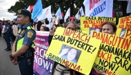 Protesters carry placards during a rally in front of the House of Representatives in Manila on February 5, 2025, as lawmakers voted to impeach Philippine Vice-President Sara Duterte. (Photo by Ted Aljibe / AFP)