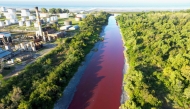 This aerial view shows an unusual reddish color of the Sarandi Canal seeping into the Rio de la Plata River in Sarandi, Avellaneda in the outskirts of Buenos Aires on February 6, 2025. (Photo by Juan MABROMATA / AFP)