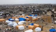 Palestinians walk around their tents, set up amid heavily damaged buildings in Jabalia, in the northern Gaza Strip, on February 6, 2025. (Photo by Bashar TALEB / AFP)
