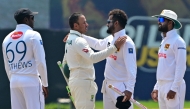 Australia's Usman Khawaja (2L) congratulates Sri Lanka's Dimuth Karunaratne (2R), who played his career's last match as Sri Lanka's Angelo Mathews (L) and Dinesh Chandimal (R) watch in Galle on February 9, 2025.  (Photo by Ishara S. Kodikara / AFP)