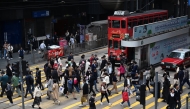 People cross an intersection in the Central business district of Hong Kong on February 27, 2024 on February 28. (Photo by Peter PARKS / AFP)