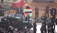 A protestor holds a Palestinian flag with the words 'Gaza' and 'Sudan' as US rapper Kendrick Lamar performs during Halftime Show at Caesars Superdome in New Orleans, Louisiana, February 9, 2025. (Photo by Chandan Khanna / AFP)