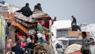 Displaced Palestinians sit in the back on a loaded truck on Salah al-Din road in al-Mughraqa in the central Gaza Strip, on February 10, 2025. (Photo by Eyad BABA / AFP)
