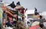 Displaced Palestinians sit in the back on a loaded truck on Salah al-Din road in al-Mughraqa in the central Gaza Strip, on February 10, 2025. (Photo by Eyad BABA / AFP)
