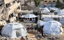 This view shows the tents of displaced Palestinians erected by a collapsed building in Gaza City on December 11, 2024. (Photo by Omar Al-Qattaa / AFP)