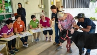 A senior participants interacts with a therapy miniature horse during the launch of Singapore's first equine-assisted program at NTUC Health Active Ageing Centre in Singapore on February 11, 2025. (Photo by Roslan RAHMAN / AFP)