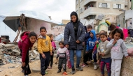 Children play with marbles near destroyed buildings at the Shati camp for Palestinian refugees north of Gaza City on February 11, 2025 amid the current ceasefire deal in the war between Israel and Hamas. (Photo by Bashar Taleb / AFP)