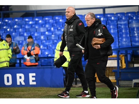 Liverpool's Dutch manager Arne Slot (L) walks on the pitch ahead of the English Premier League football match between Everton and Liverpool at Goodison Park in Liverpool, north west England on February 12, 2025. (Photo by Paul ELLIS / AFP)