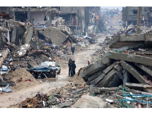 Palestinians walk amid the devastation in Beit Hanun in the northern Gaza Strip on February 12, 2025. (Photo by Omar Al-Qattaa / AFP)