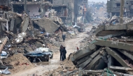 Palestinians walk amid the devastation in Beit Hanun in the northern Gaza Strip on February 12, 2025. (Photo by Omar Al-Qattaa / AFP)