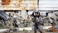 A Palestinian boy carries a container on his head in al-Mughraqa in the central Gaza Strip, on February 13, 2025. Photo by Eyad BABA / AFP