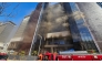 Firefighters work at the scene of a fire at a construction site of the Banyan Tree Hotel in the southern port city of Busan on February 14, 2025. (Photo by YONHAP / AFP) 