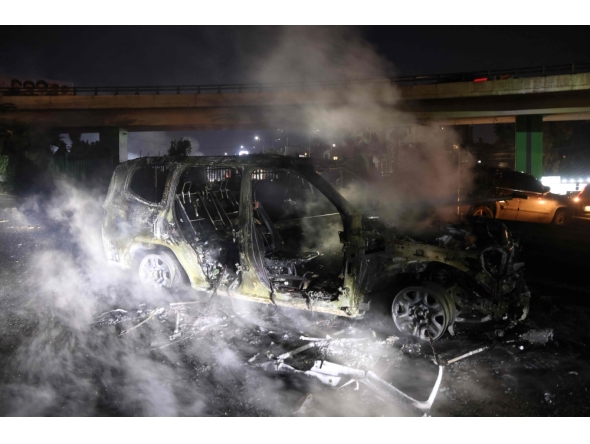 Smoke billows from the burnt remains of a UNIFIL vehicle, set ablaze by protesters, on the road leading to Beirut's international airport on February 14, 2025. (Photo by Ibrahim Amro / AFP)