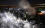 Smoke billows from the burnt remains of a UNIFIL vehicle, set ablaze by protesters, on the road leading to Beirut's international airport on February 14, 2025. (Photo by Ibrahim Amro / AFP)