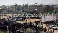 Red Cross vehicles wait at the spot where Hamas is expected to hand over Israeli hostages in Khan Yunis in the southern Gaza Strip on February 15, 2025. (Photo by Bashar Taleb / AFP)
 