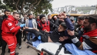 Paramedics transport a youth injured during a military raid in the old town of Nablus in the occupied West Bank on February 16, 2025. (Photo by JAAFAR ASHTIYEH / AFP)
