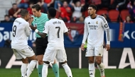 Real Madrid's French forward #09 Kylian Mbappe and Real Madrid's Brazilian forward #07 Vinicius Junior remonstrate with Spanish referee Munuera Montero about the red card presented to Real Madrid's English midfielder #05 Jude Bellingham (R) during the Spanish league football match between CA Osasuna and Real Madrid CF at El Sadar Stadium in Pamplona on February 15, 2025. (Photo by ANDER GILLENEA / AFP)
