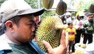 A man smells a local durian at a durian market in Randulanang village in Klaten Regency, Central Java, Indonesia, Feb. 16, 2025. (Photo by Bram Selo/Xinhua)
