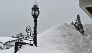 This photo taken on January 31, 2025 shows a sign for a hotel buried amongst snow piled high, along a street in the ski resort town of Hakuba, Nagano prefecture. Photo by Richard A. Brooks / AFP