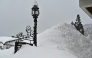 This photo taken on January 31, 2025 shows a sign for a hotel buried amongst snow piled high, along a street in the ski resort town of Hakuba, Nagano prefecture. Photo by Richard A. Brooks / AFP